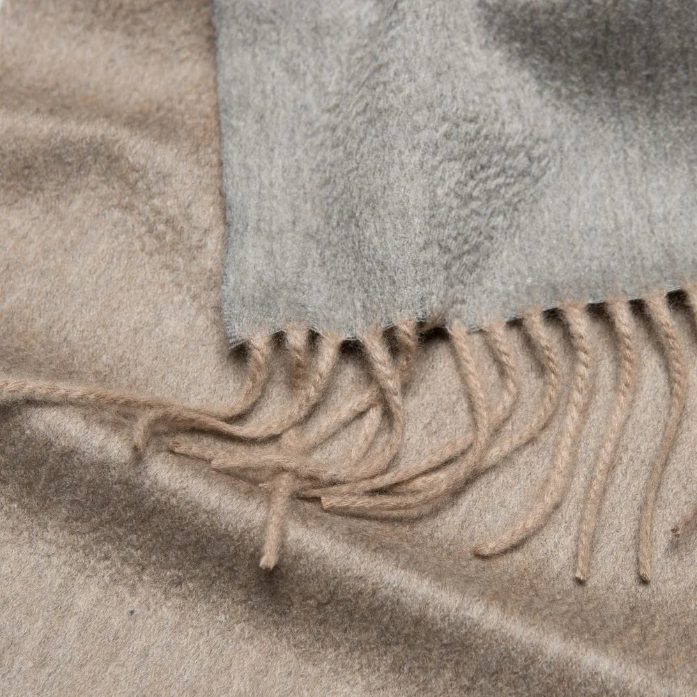 Close-up of a textured fabric with frayed edges in neutral tones.