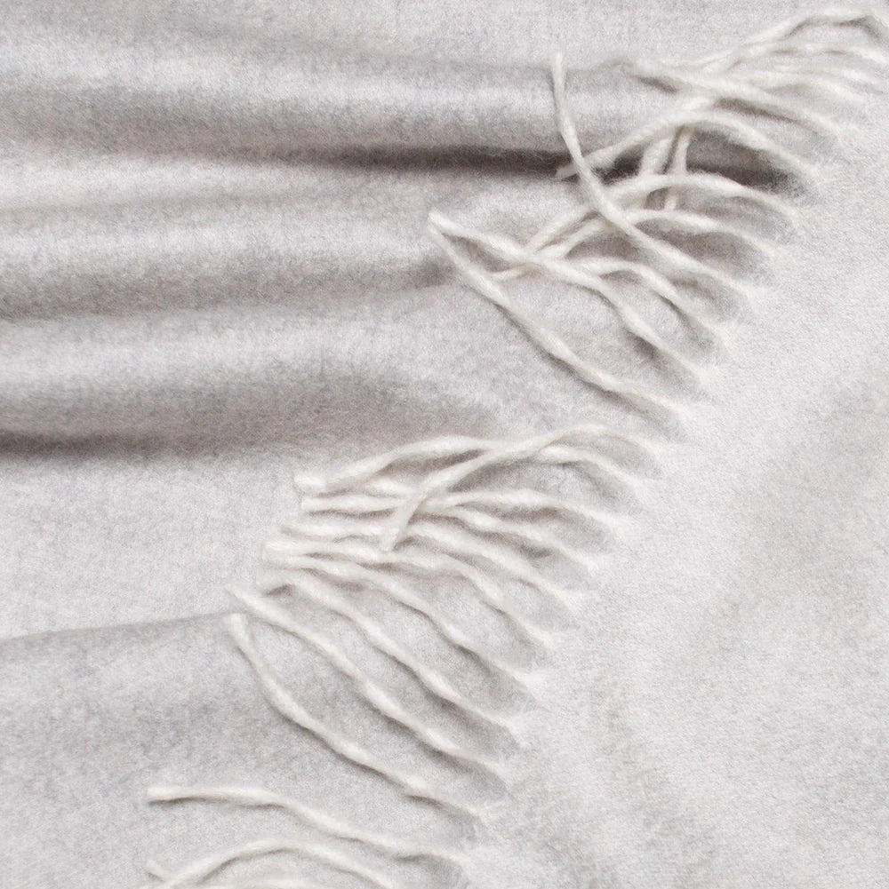 Silver throw with white fringe on a silver background