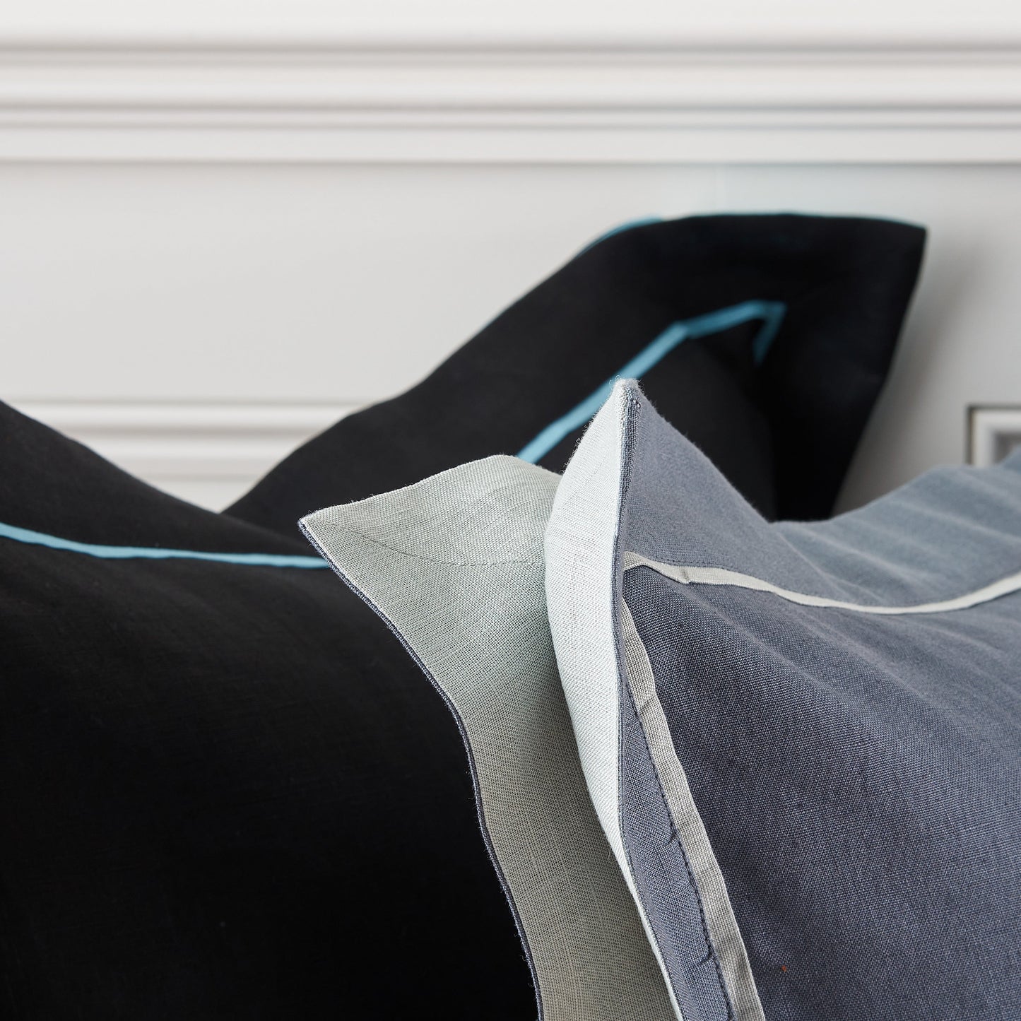 Decorative pillows with blue and gray trim on a neutral background