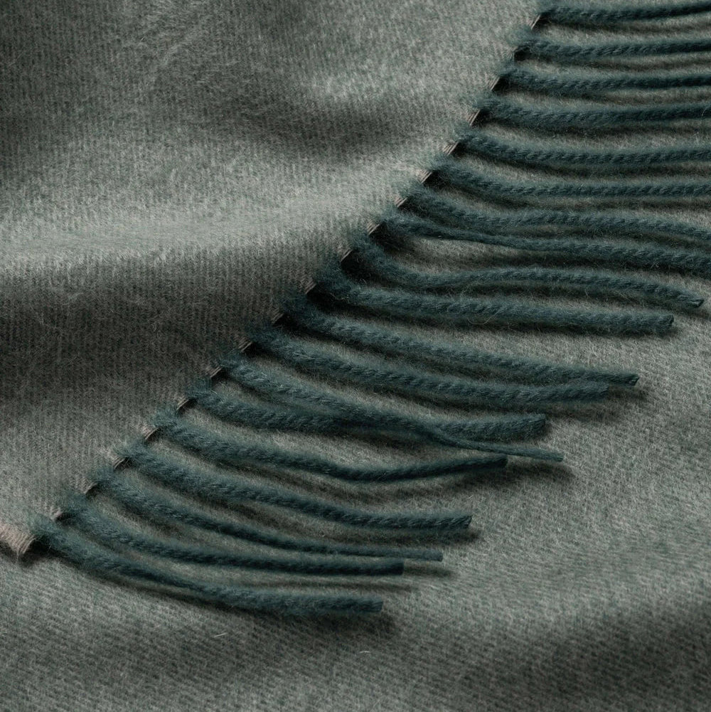 Close-up of a green blanket with frayed edges